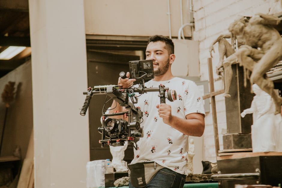 Professional wedding videographer filming a couple outdoors